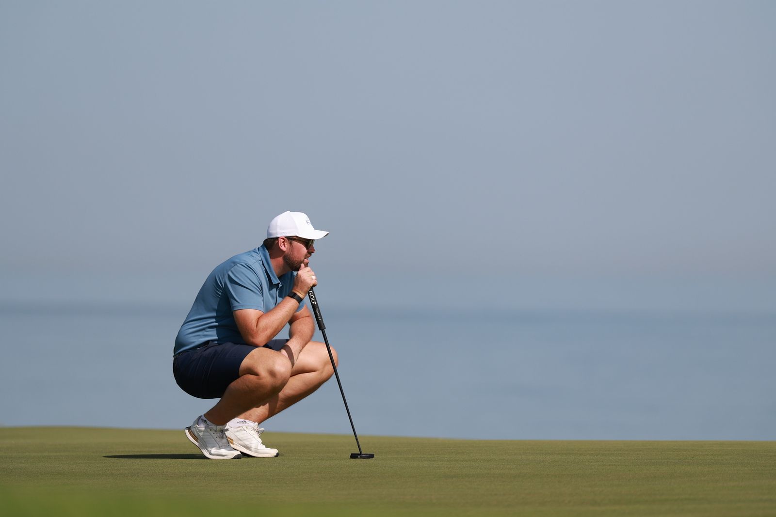 Stephen Wilson lining up a putt on a coastal golf course
